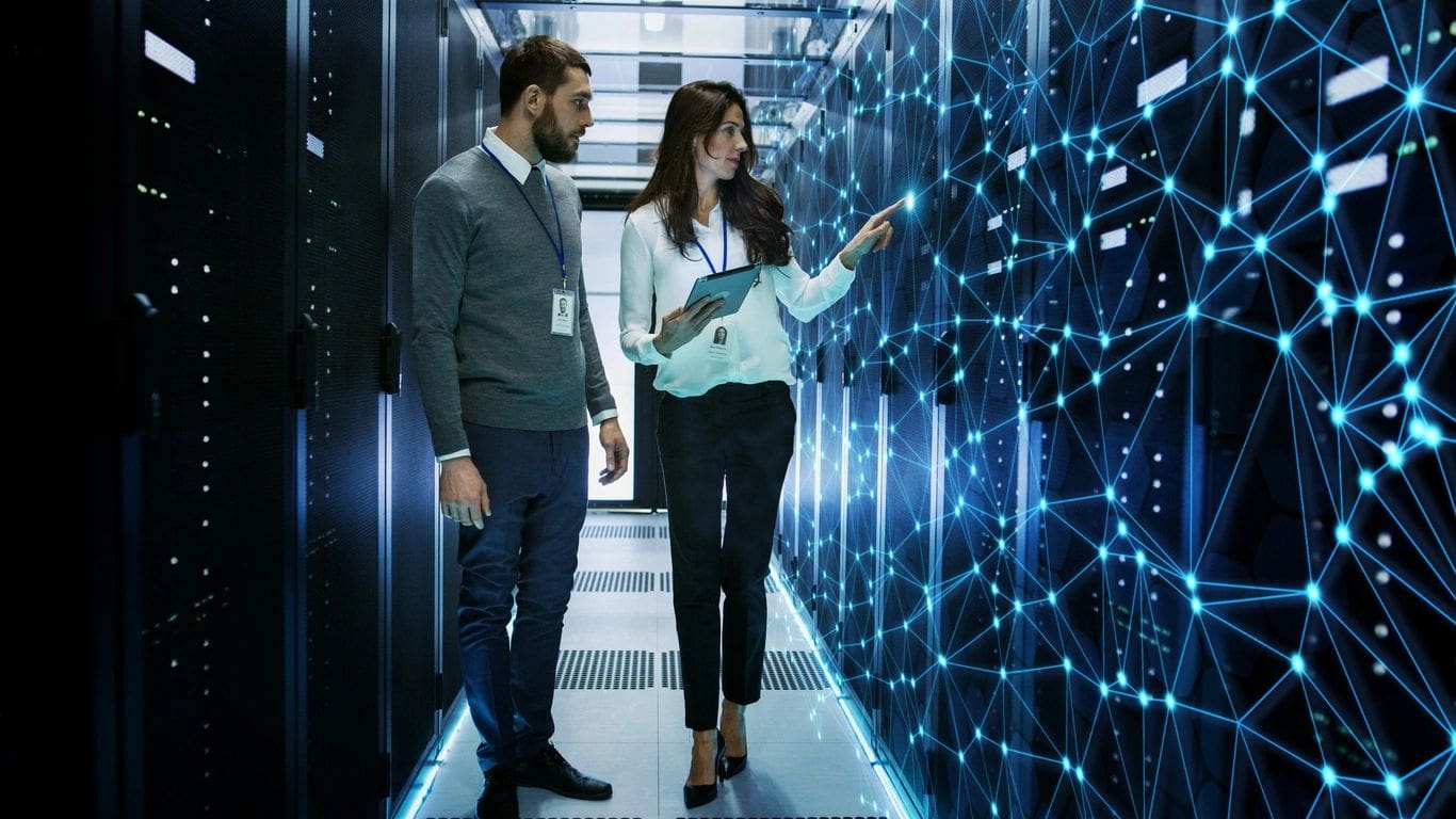 Two professionals reviewing systems in a data center